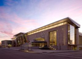 Exterior photo of the Raleigh Convention Center with a pink and purple sunset in the background